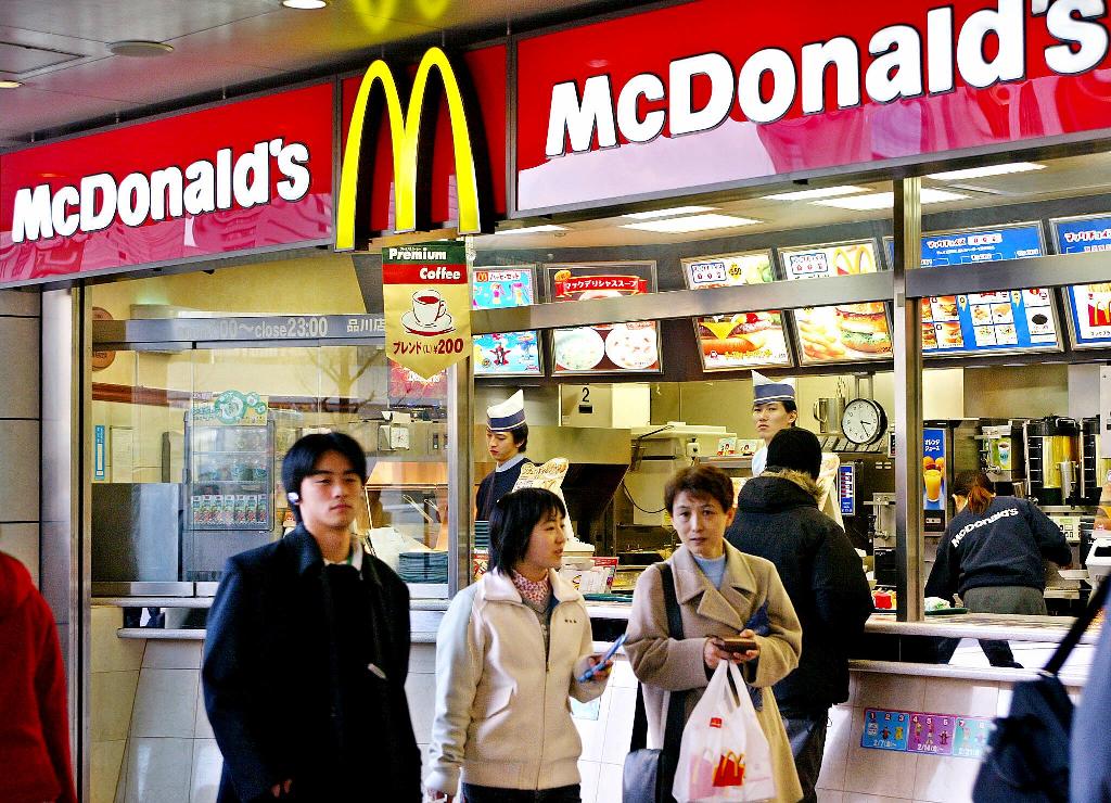 (FILES) This file photo taken on February 15, 2003 shows people walking past a McDonald's restarant in downtown Tokyo.  AFP / Yoshikazu TSUNO
