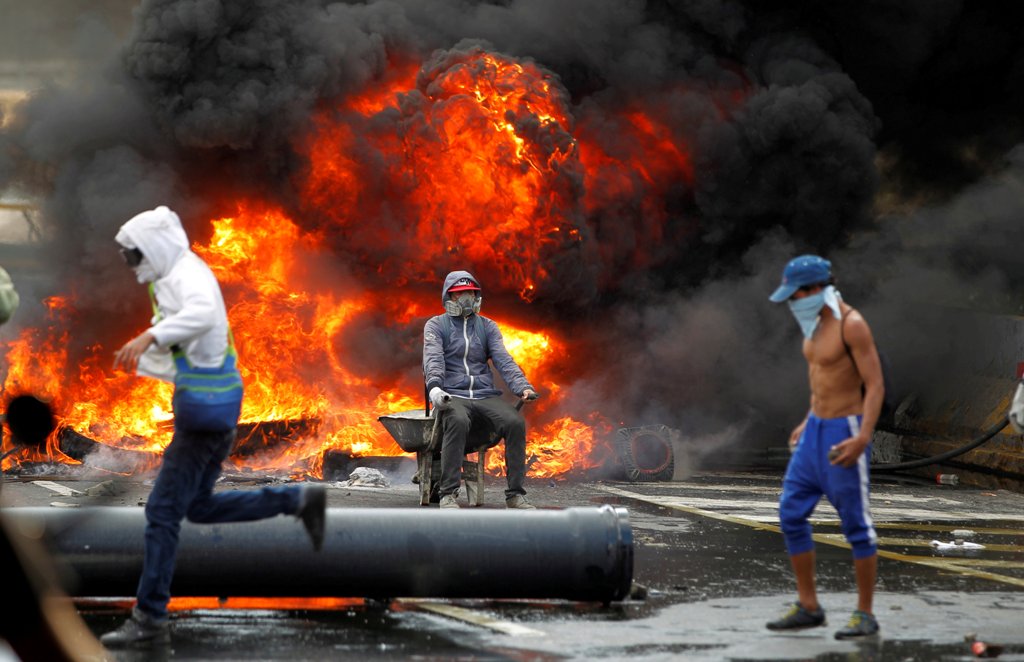 FILE PHOTO: Demonstrators build a fire barricade on a street during a rally against Venezuela's President Nicolas Maduro in Caracas, Venezuela April 24, 2017. REUTERS/Christian Veron/File Photo
