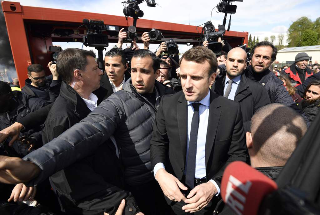 French presidential election candidate for the En Marche ! movement Emmanuel Macron arrives outside Whirlpool factory outside the Amiens Cathedral on April 26, 2017.   AFP / POOL / Eric FEFERBERG
