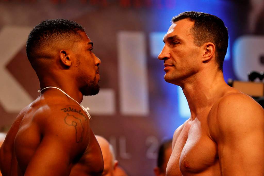 British boxer Anthony Joshua (L) and Ukrainian boxer Wladimir Klitschko (R) face each other during the weigh-in ahead of their world heavyweight title unification bout at Wembley in London on April 28, 2017.  / AFP / Adrian DENNIS
