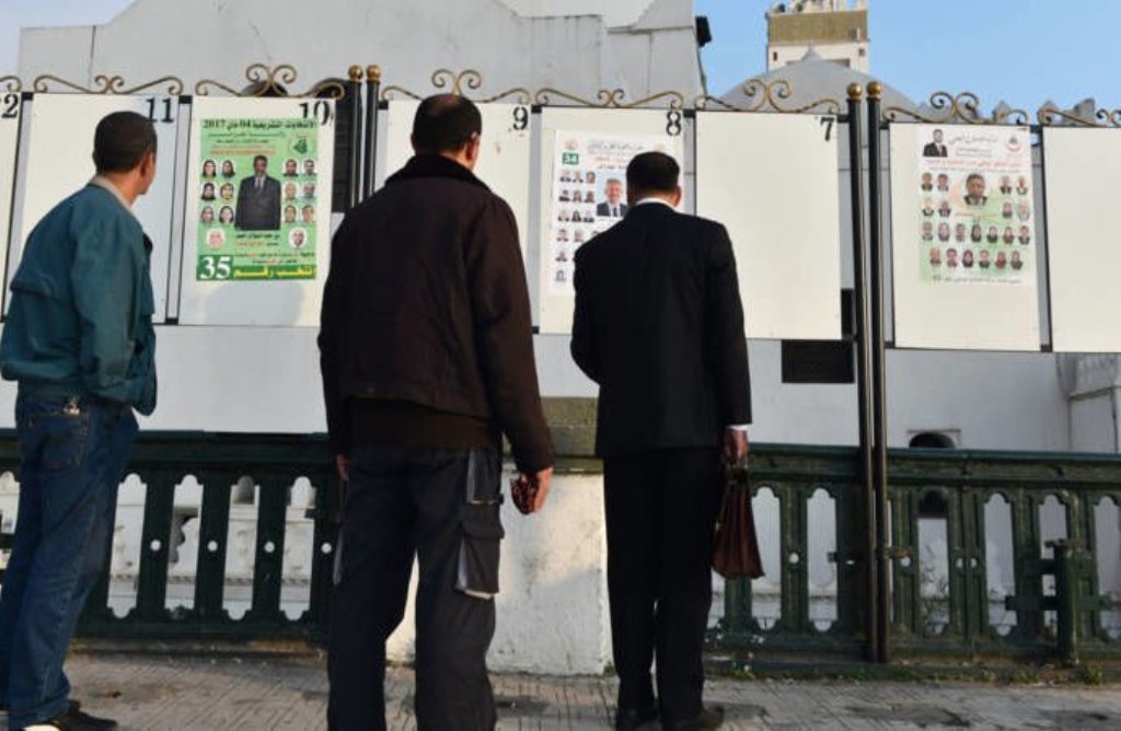 Algerian men look at electorial campaign posters for the upcoming legislative elections in Algiers' Martyrs Square as the official start of campaigning got underway on April 9, 2017.Ryad Kramdi/AFP