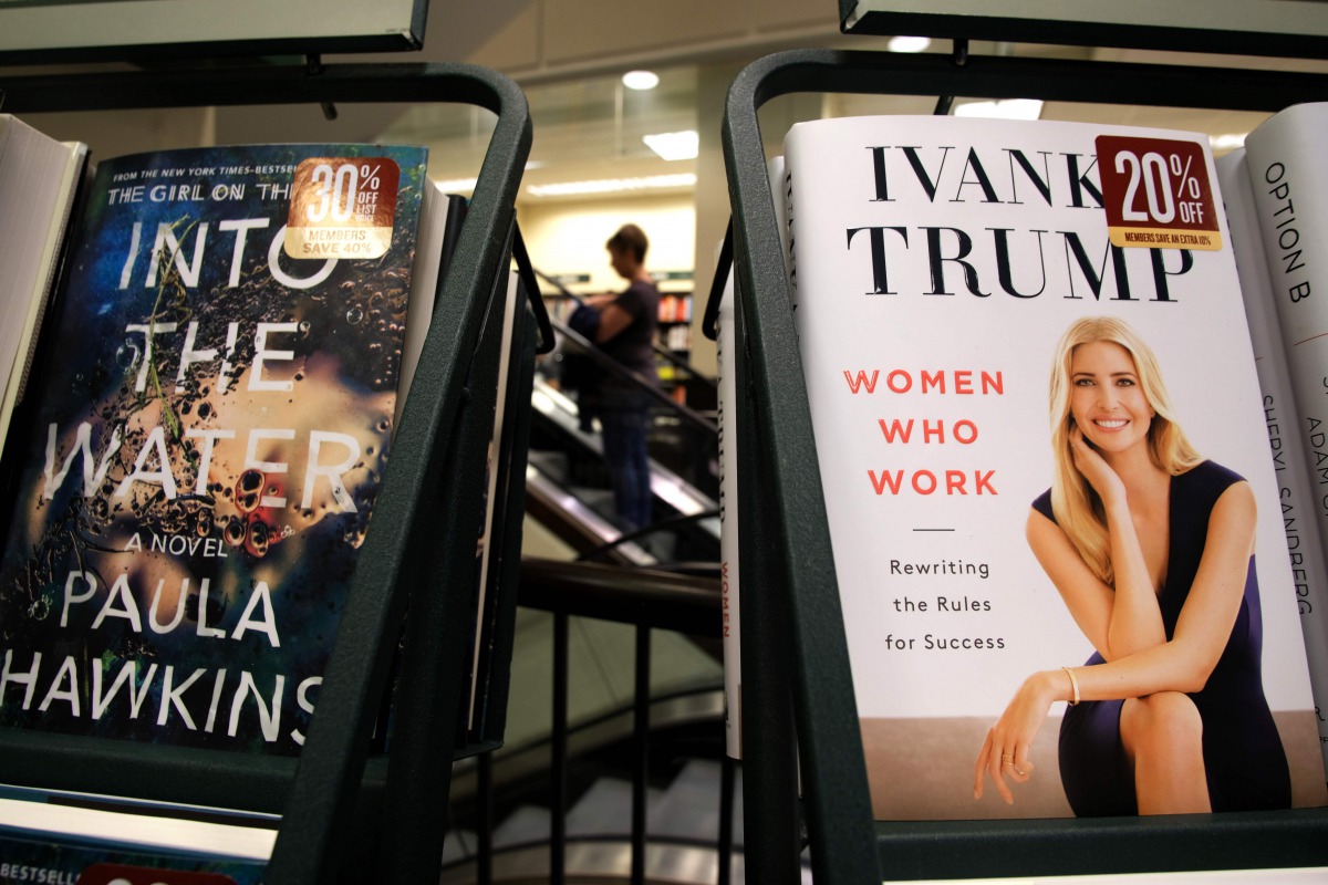 A woman walks past a shelf displaying Ivanka Trump's book 