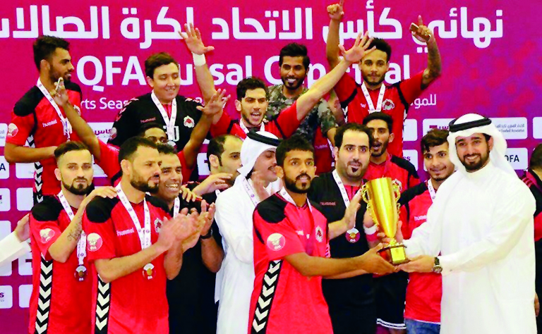 Al Rayyan captain receiving the QFA Futsal Cup from QFA Secretary General Mansoor Al Ansari after defeating Al Gharafa in the final at Suheim Bin Hamad Stadium on Monday. 
