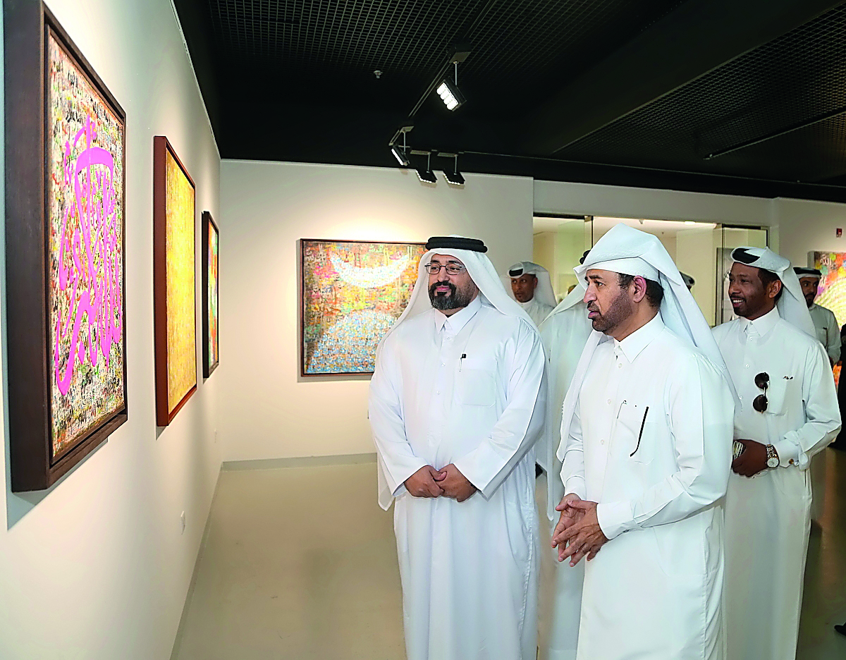 Visitors look at the artworks displayed at the exhibition.