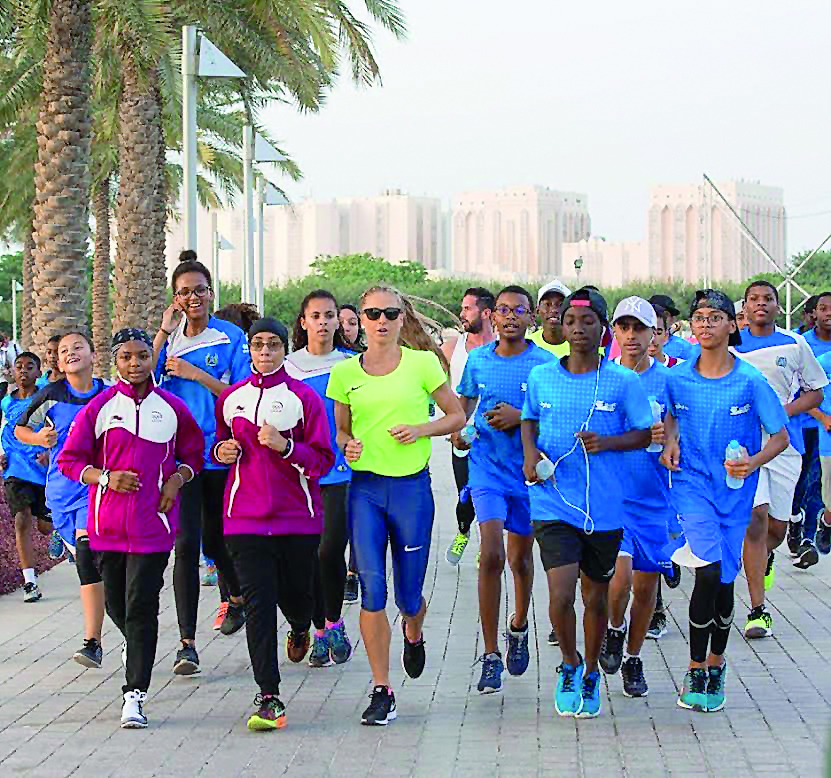 Australia's Genevieve Lacaze (centre) runs with schoolchildren during the inspiring event at MIA Park 