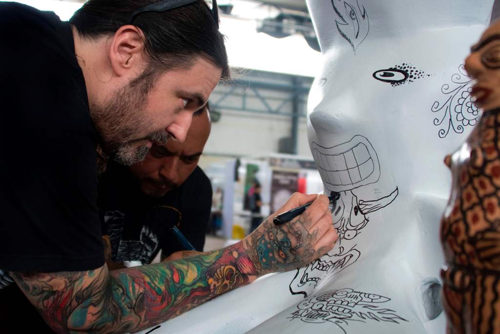 A tattoo artist draws at the 6th Edition of the Paradise Tattoo Convention in San Antonio de Belen, 20 km west of San Jose, Costa Rica on May 5, 2017, which drew more than 300 local and international tattoo artists. / AFP / EZEQUIEL BECERRA
