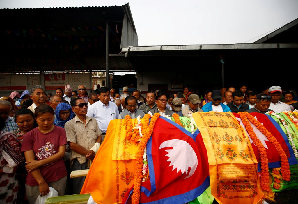 People observe a minute of silence near the body of Nepali mountain climber Min Bahadur Sherchan, 85, who died on Saturday, at base camp while on his attempt to become the oldest person to climb Mount Everest, in Kathmandu, Nepal May 7, 2017. REUTERS/Nave
