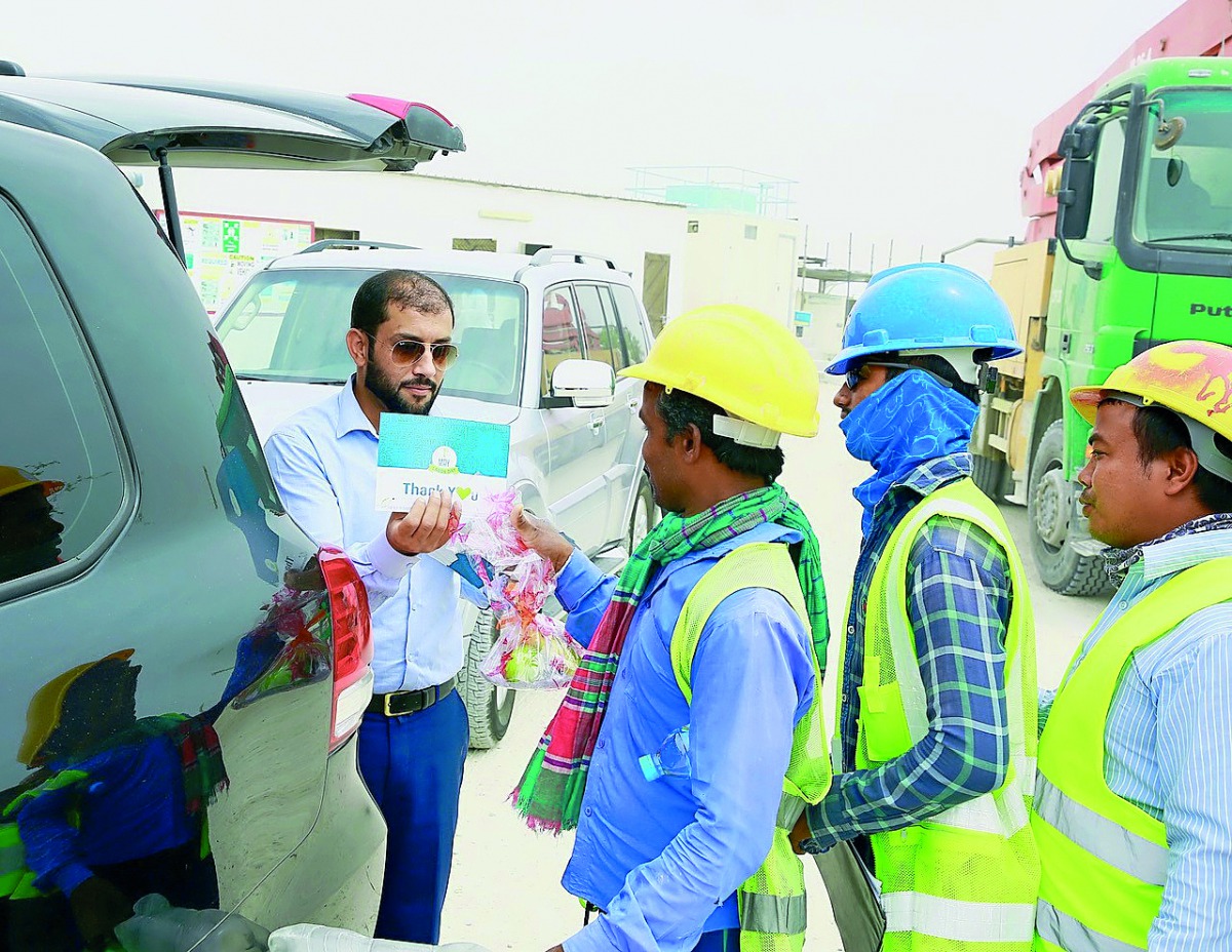 Labourers receiving fresh fruits and awareness cards on World Labour Day.