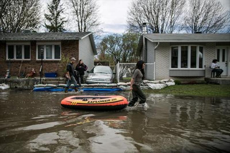 A resident of Ile Mercier south of Quebec pulls a rubber boat in the floods on Saturday 6, 2017.  ( Amru Salahuddien - Anadolu Agency )