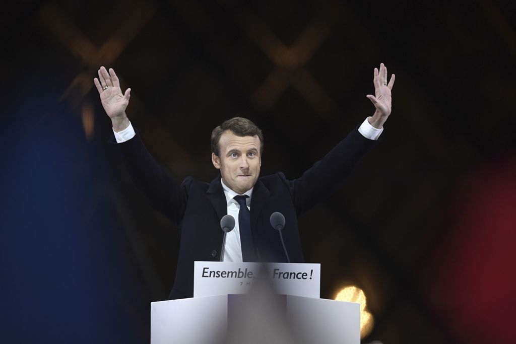 French president-elect Emmanuel Macron greets supporters as he arrives to deliver a speech in front of the Pyramid at the Louvre Museum in Paris on May 7, 2017, after the second round of the French presidential election. / AFP.