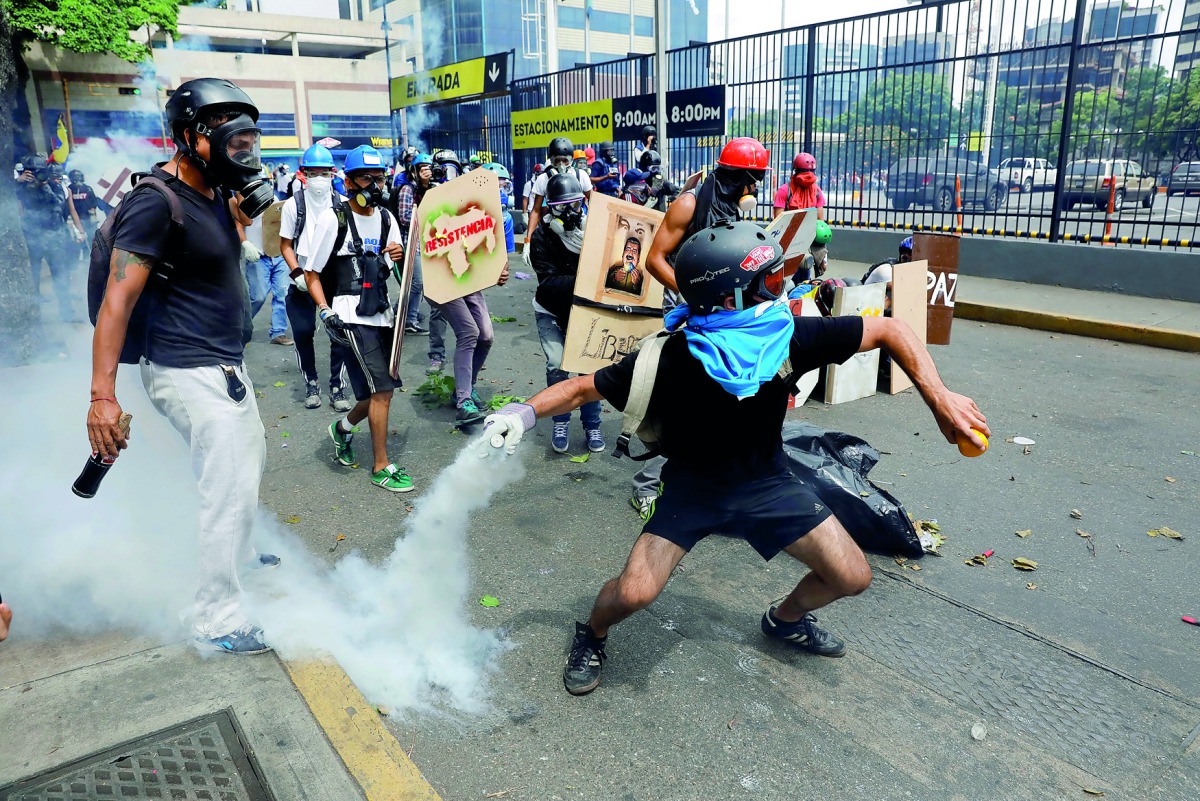 Opposition supporters clash with riot police during a rally against President Nicolas Maduro in Caracas, yesterday.