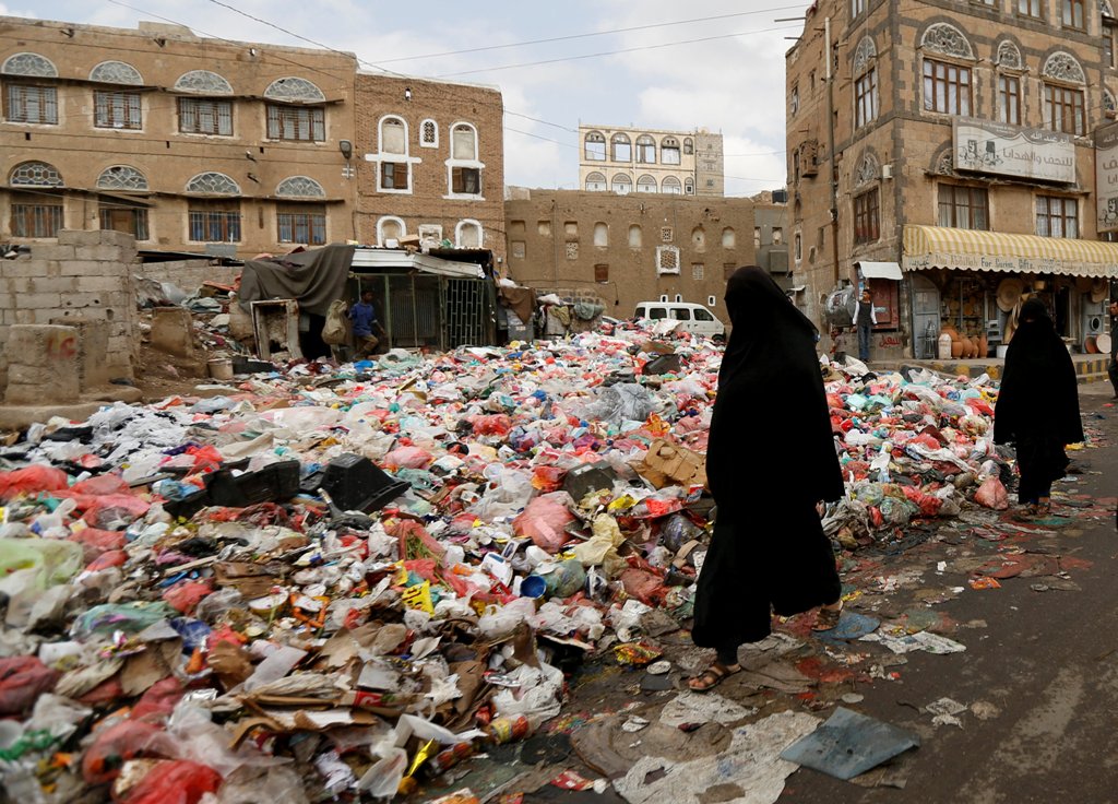 Women walk past a pile of rubbish bags on a street during a strike by garbage collectors demanding delayed salaries in Sanaa, Yemen May 8, 2017. REUTERS/Khaled Abdullah
