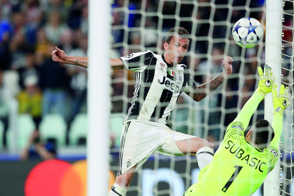 Juventus' Croatian forward Mario Mandzukic (left) scores a goal past Monaco's goalkeeper Danijel Subasic during the UEFA Champions League semi-final second leg football match played at the Juventus stadium in Turin yesterday. Juventus beat Monaco 2-1 and 