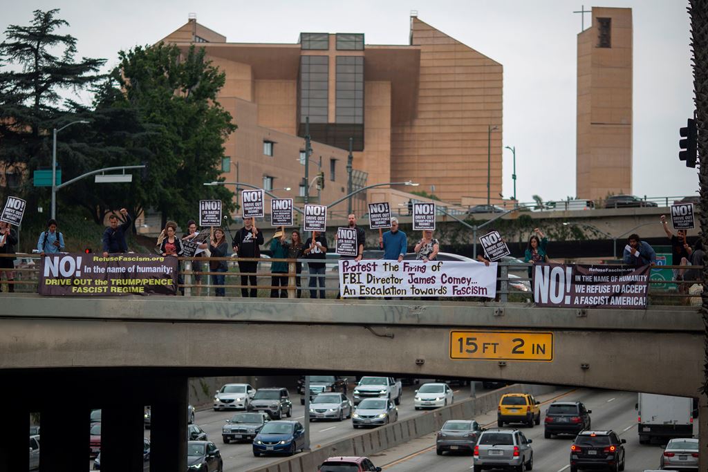 Protesters on an overpass above the 101 freeway denounce the firing of FBI Director James Comey by US President Donald Trump amid investigations into possible collusion between Trump advisors and the Russian government on May 10, 2017 in Los Angeles, Cali