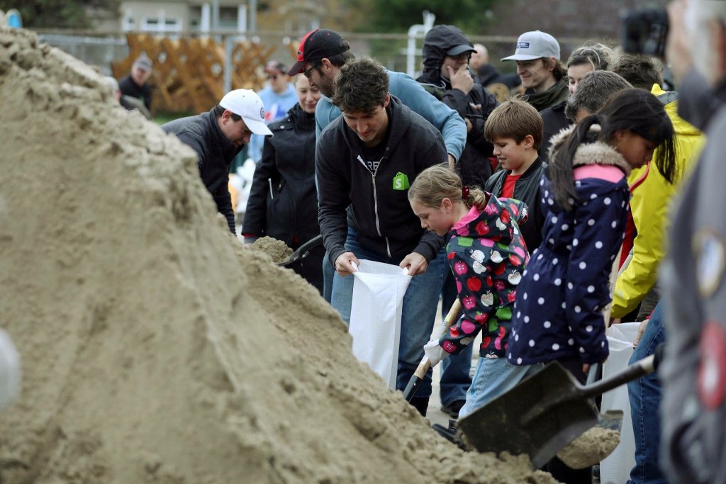 Canada's Prime Minister Justin Trudeau (C) helps fill sandbags after flooding in Terrasse-Vaudreuil, Quebec, Canada May 7, 2017. Adam Scotti/Prime Minister's Office
