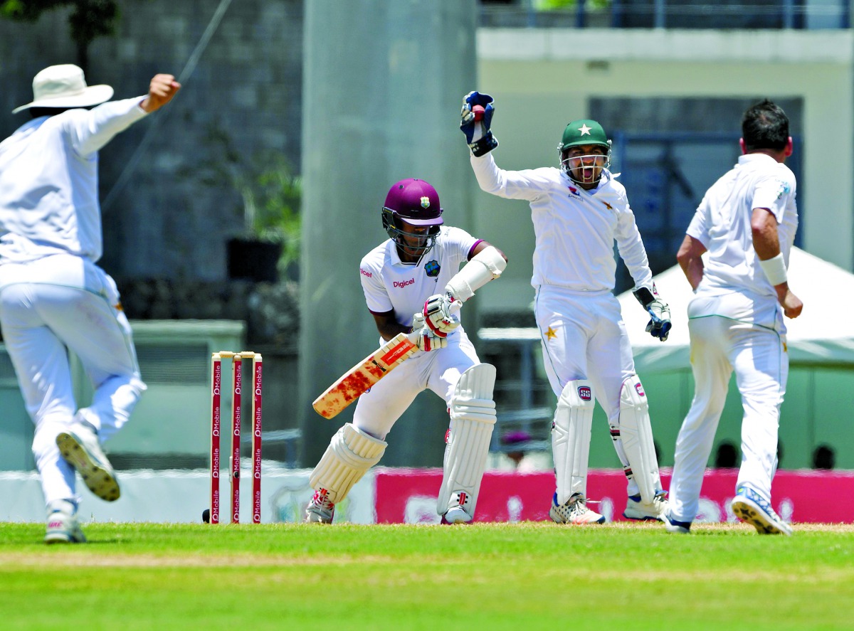 Pakistan wicketkeeper Sarfraz Ahmed (centre) successfully appeals for the wicket of West Indies batsman Kraigg Brathwaite after taking the catch off the bowling of Yasir Shah (right) during the third day's play of the third and final Test match at the Win