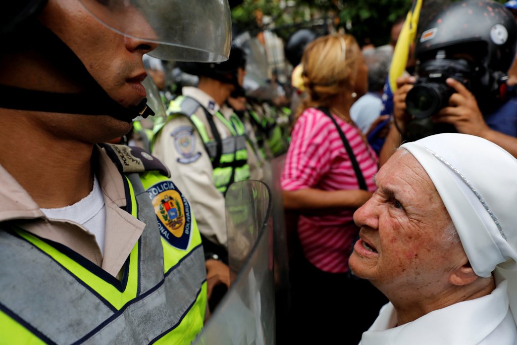 A nun (R) confronts riot security forces while rallying against President Nicolas Maduro in Caracas, Venezuela, May 12, 2017. REUTERS/Carlos Garcia Rawlins
