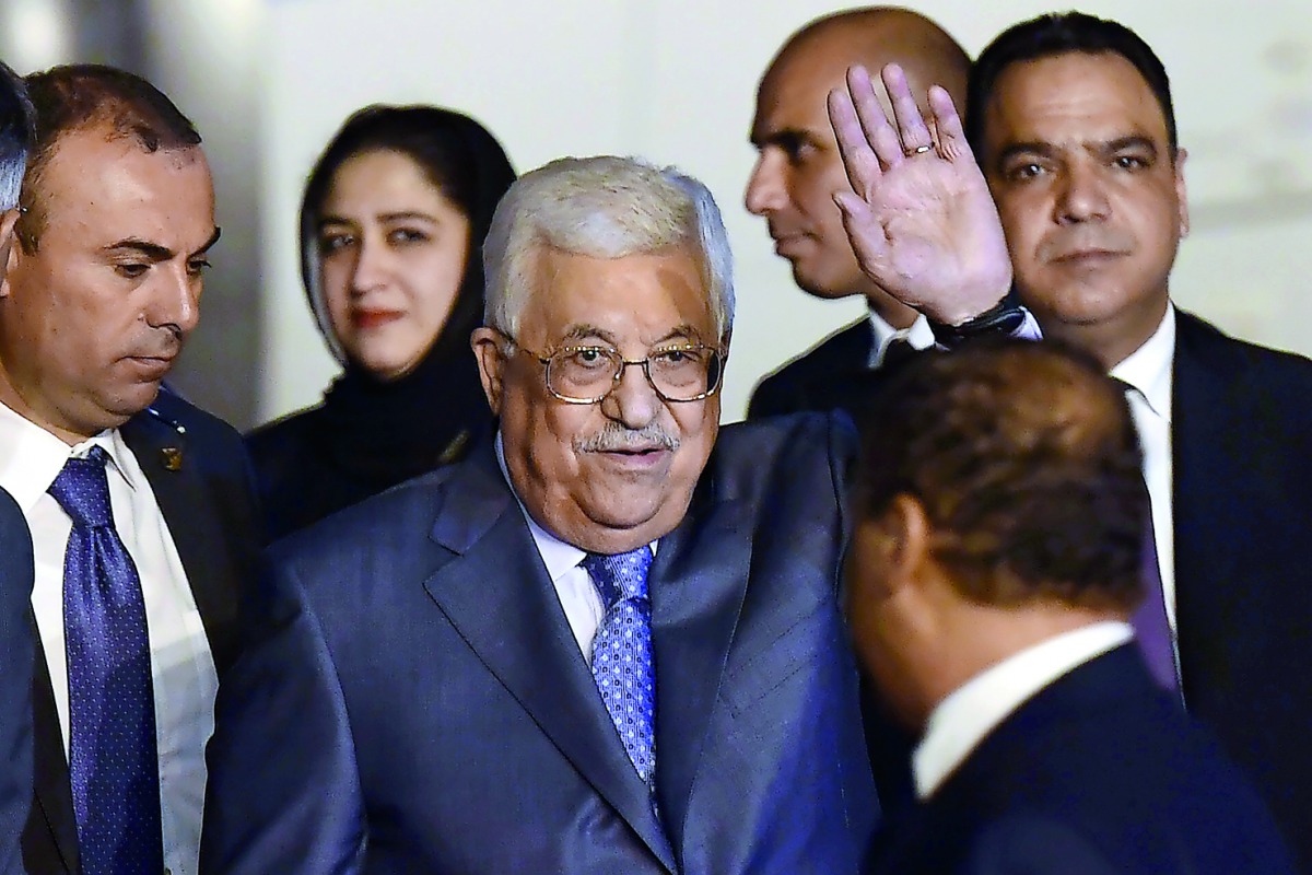Palestine President Mahmoud Abbas waves as he walks with officials after arriving at Palam Air Force Station in New Delhi on May 14, 2017. Palestine President Mahmoud Abbas is on a four day state visit to India till May 17.  AFP / Prakash Singh
