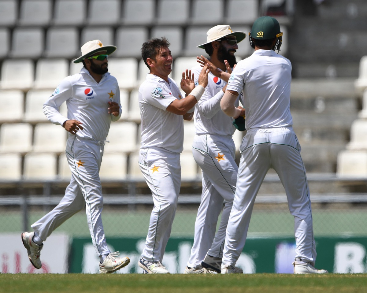 Pakistani bowler Yasir Shah (second left) celebrates with team-mates after taking the wicket of West Indies batsman Kraigg Brathwaite on the fifth day's play of the final Test match at the Windsor Park Stadium in Roseau, Dominica.