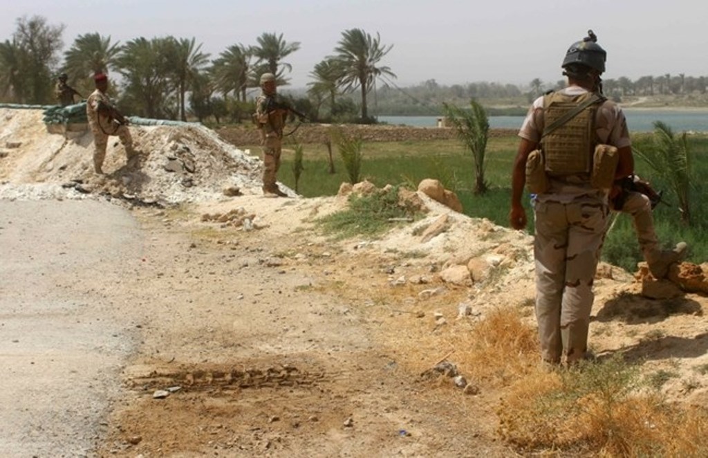 Members of the Iraqi government forces keep watch on August 15, 2016 in Dulab, in Haditha, west of Ramadi, the capital of Iraq's Anbar province, after pro-government forces recaptured the area from ISIS. / AFP / MOADH AL-DULAIMI.