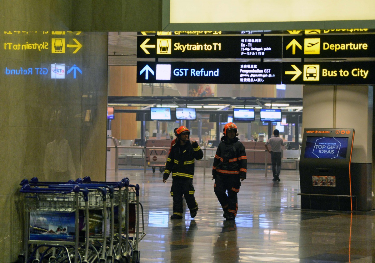 Firemen inspect Changi International Airport terminal 2 in Singapore on May 16, 2017. Hundreds of passengers were evacuated from Singapore's Changi Airport on May 16 after a small fire erupted in a terminal that was quickly extinguished, authorities and w