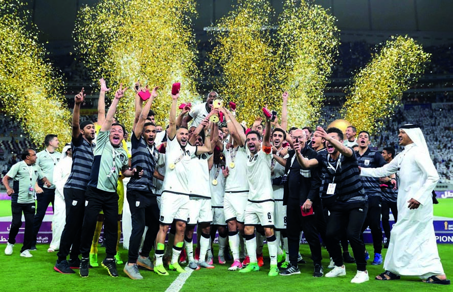 The jubilant Al Sadd players and officials celebrate with 2017 Emir's Cup at Khalifa International Stadium yesterday. Al Sadd registered a fighting 2-1-win over Al Rayyan in an exciting final to bag their 16th Emir Cup title.