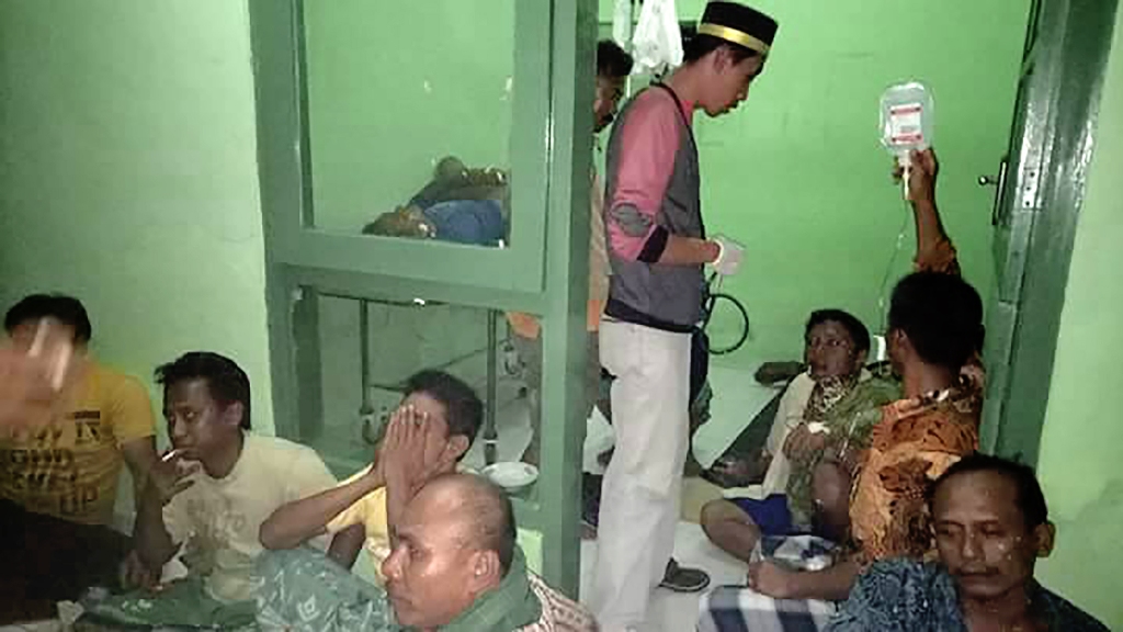 In this handout photograph taken and released on May 20, 2017 by Indonesia National Search and Rescue Agency shows the survivors of a vessel that caught fire on its car deck, at a local clinic in Masalembu Island, in between Java and Kalimantan mail islan