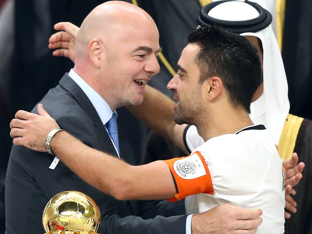 Al-Sadd's Spanish capitan Xavi (R) is embraced by FIFA President Gianni Infantino during the presentation of the trophy following the Qatar Emir Cup Final football match between Al-Sadd and Al-Rayyan at the Khalifa International Stadium in Doha on May 19,