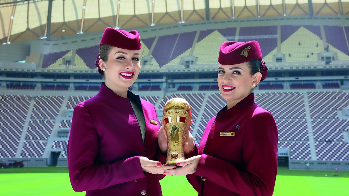 Qatar Airways hostesses display the Emir Cup trophy. 