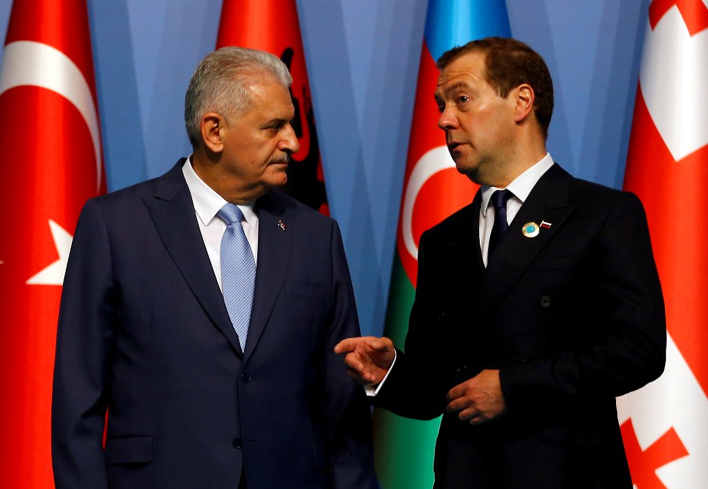 Turkish Prime Minister Binali Yildirim and his Russian counterpart Dmitry Medvedev chat as they pose for a group photo during the 25th anniversary summit of the Organisation of the Black Sea Economic Cooperation (BSEC) in Istanbul, Turkey, May 22, 2017. R