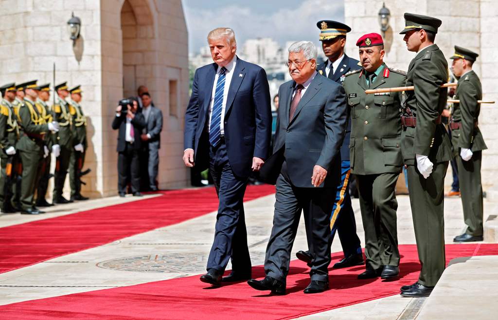 US President Donald Trump (L) and Palestinian leader Mahmud Abbas (2nd L) review the honour guard at the presidential palace in the West Bank city of Bethlehem on May 23, 2017. / AFP / THOMAS COEX.