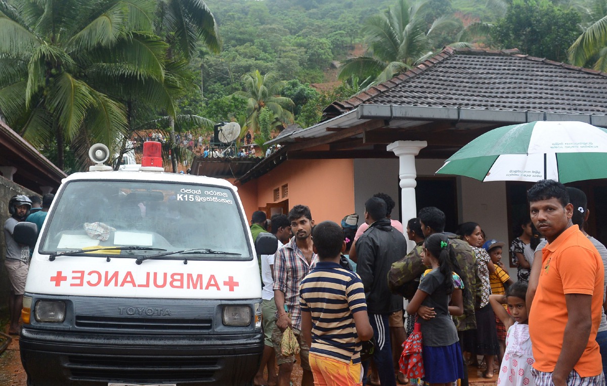 Sri Lankan villagers watch as military rescue workers search for survivors at the site of a mudslide in Bellana village in Kalutara on May 26, 2017.  AFP / Lakruwan Wanniarachchi