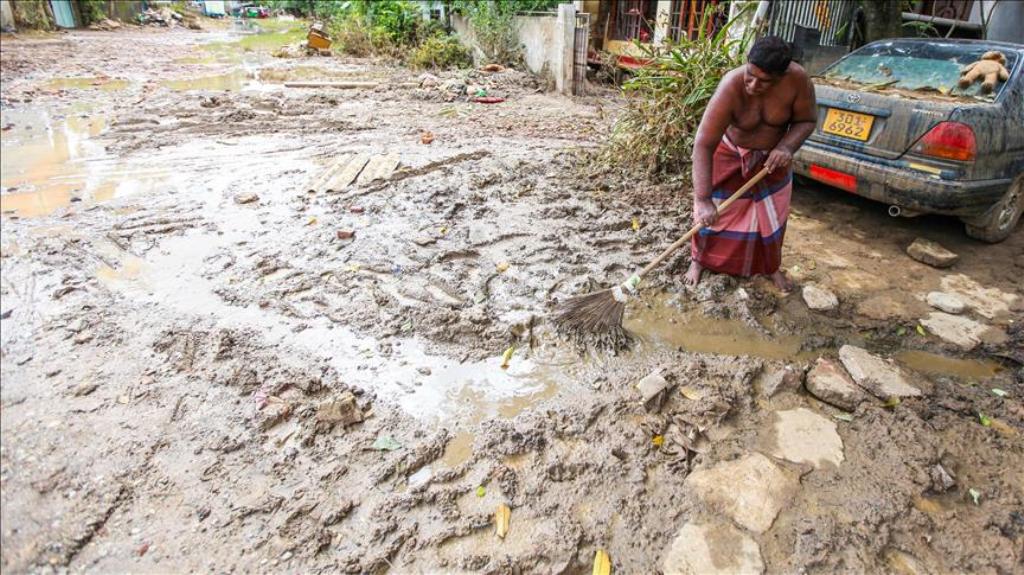 A Sri Lankan flood victim cleans as the water level starts to decline in Wellampitiya, neighborhood of Colombo, Sri Lanka on May 25, 2016. ( Chamila Karunarathne - Anadolu Agency ).
