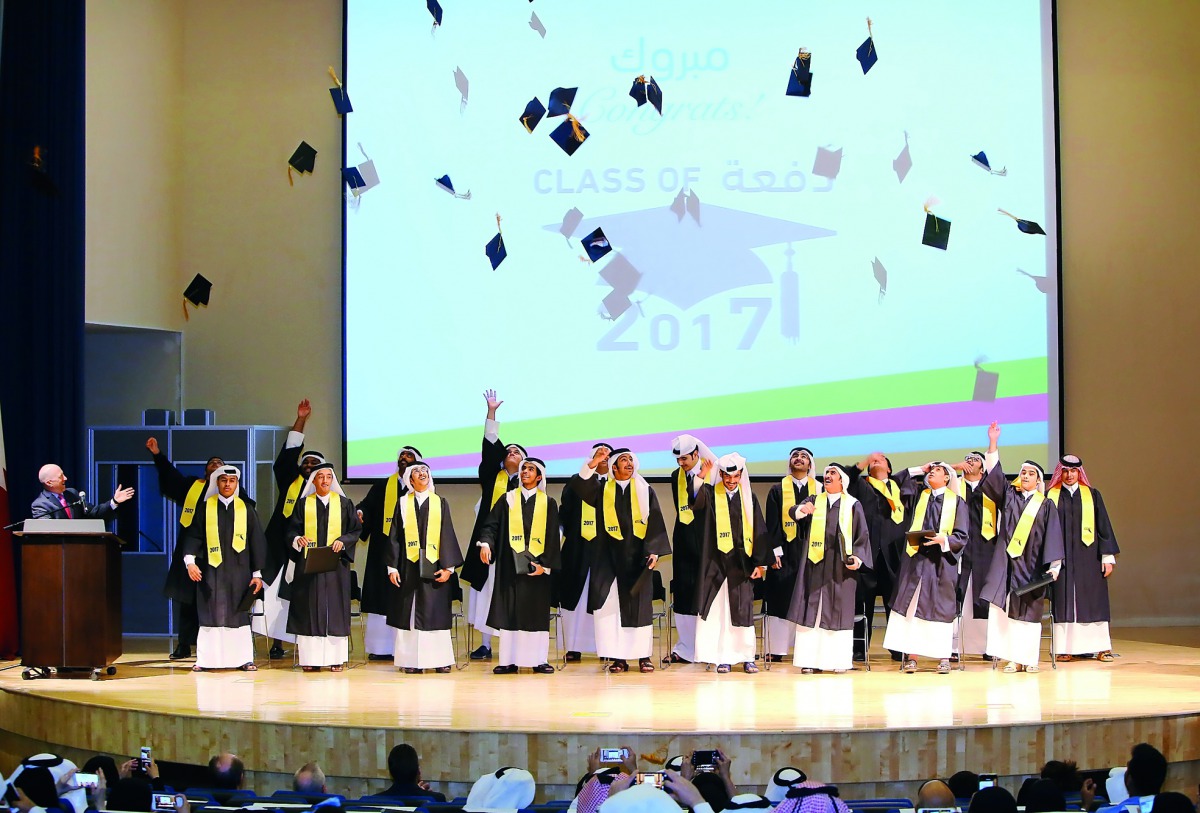 Students of the 11th graduating class of Awsaj Academy celebrate by throwing their graduation caps in the air. 