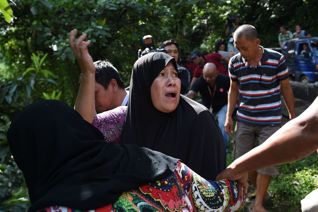 A woman calls out to her relatives after identifying bodies dumped off a cliff along the highway leading to Marawi on the southern island of Mindanao on May 28, 2017. AFP / Ted Aljibe 