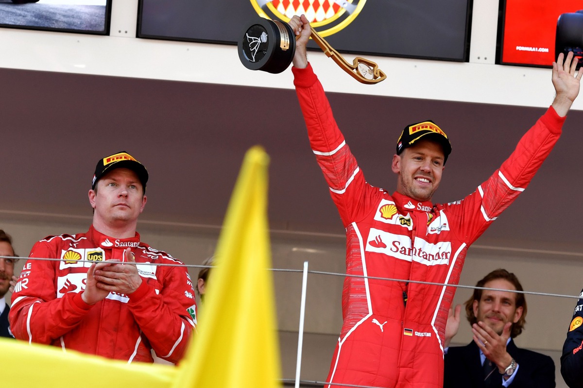 Winner Ferrari's German driver Sebastian Vettel (R) celebrates on the podium next to second placed Ferrari's Finnish driver Kimi Raikkonen after the Monaco Formula 1 Grand Prix at the Monaco street circuit, on May 28, 2017 in Monaco. / AFP / ANDREJ ISAKOV