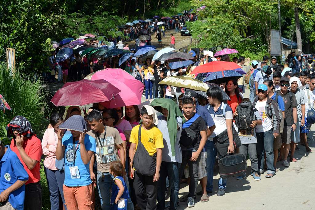 Residents and commuters queue up at a police checkpoint at the entrance to Iligan City on the southern island of of Mindanao on May 29, 2017, after local authorities locked down the city due to a terror threat. AFP / Ted ALJIBE
