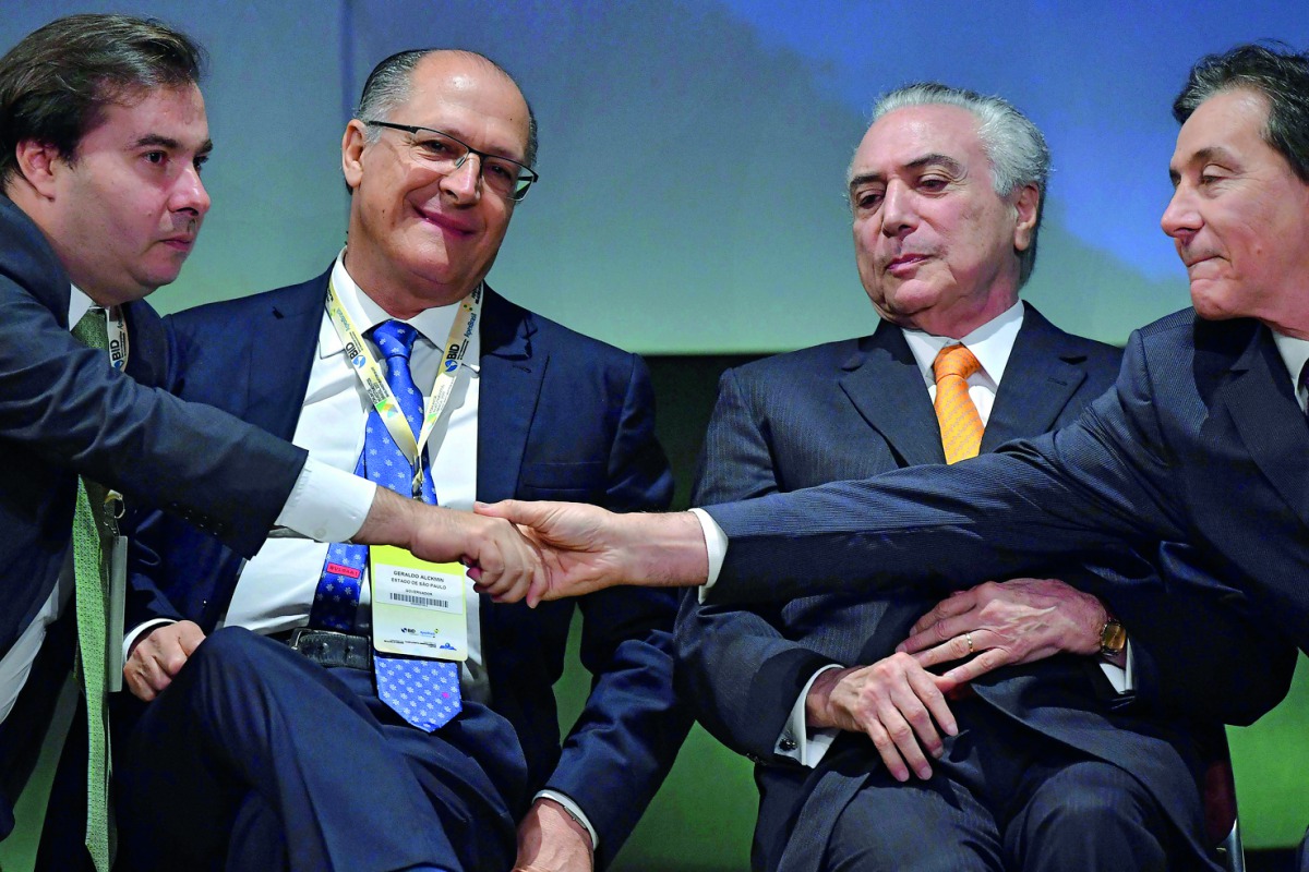 President of the Brazilian lower house Rodrigo Maia (L) shakes hands with president of the Brazilian senate Eunicio Oliveira (R) next to Brazilian President Michel Temer (2-R) and Sao Paulo's governor Geraldo Alckmin, during an Investment Forum in Sao Pau