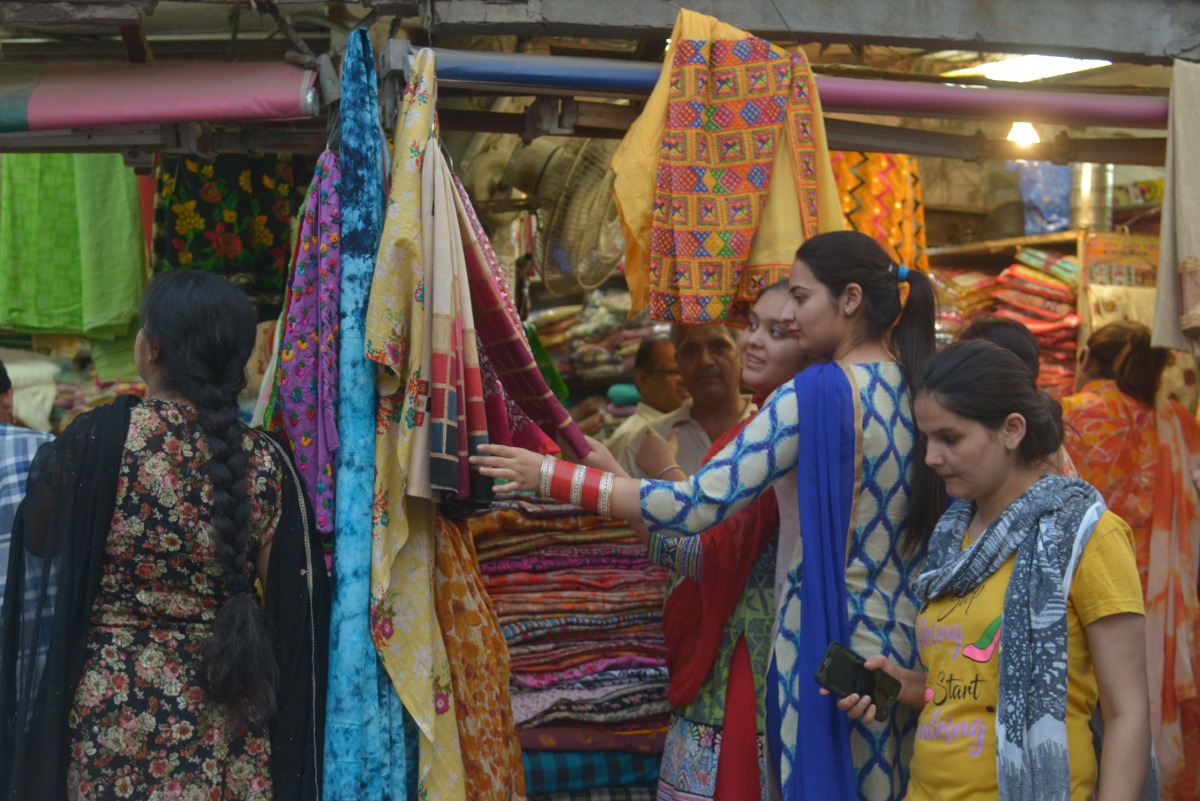 Indian customers browse at a shop selling women's suits and wedding outfits in a market in Amritsar on May 30, 2017. (AFP / NARINDER NANU)
