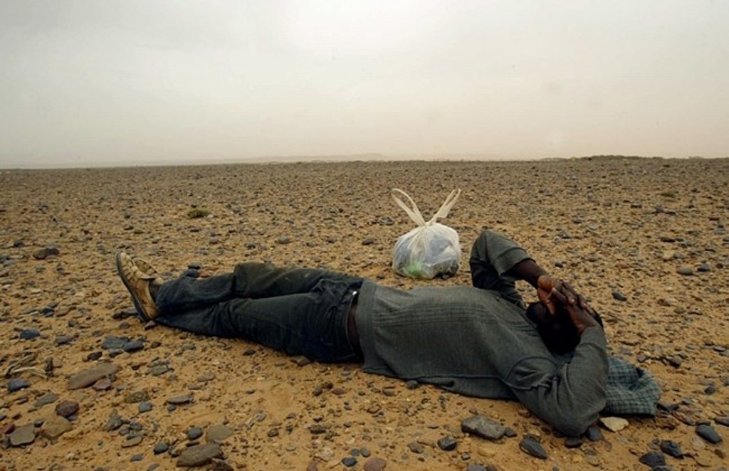(FILES) This picture taken on October 8, 2005 shows a would-be immigrant resting in the middle of the Sahara Desert, near the border with Algeria. AFP PHOTO / SAMUEL ARANDA
