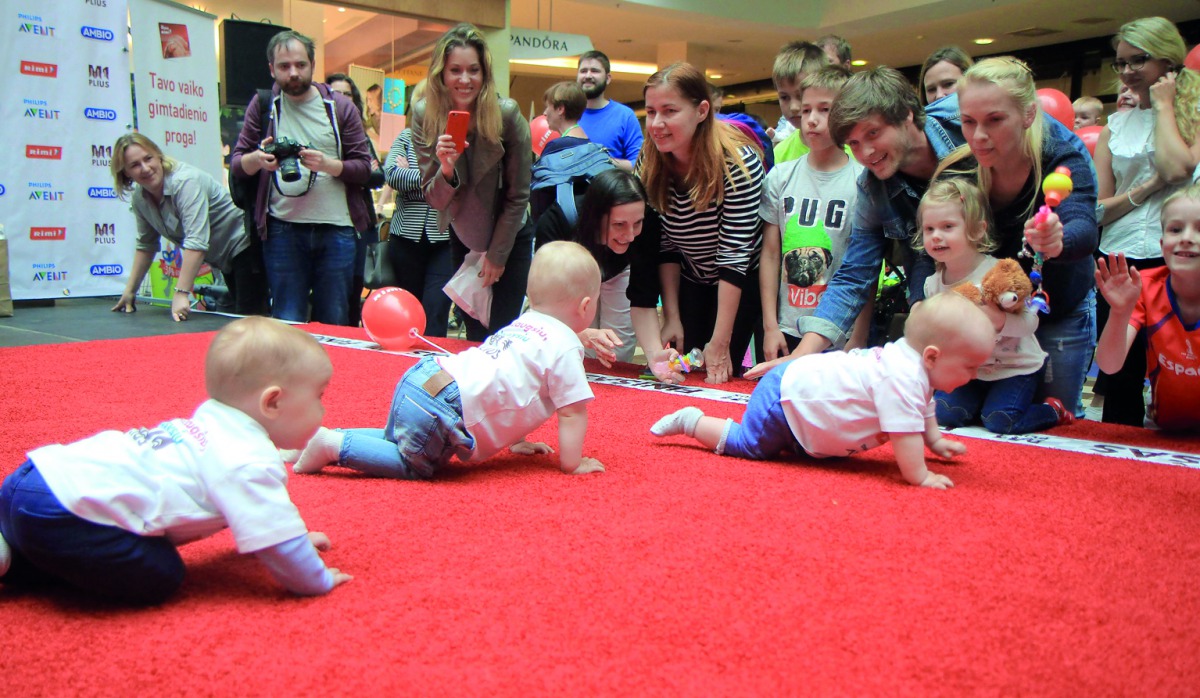 Babies take part in a Baby Race to mark International Children's Day in Vilnius, Lithuania, yesterday. Parents and grandparents waved colourful toys, mobile, phones, balloons, TV remote controls, plastic bottles and even bagels to get their tots across th