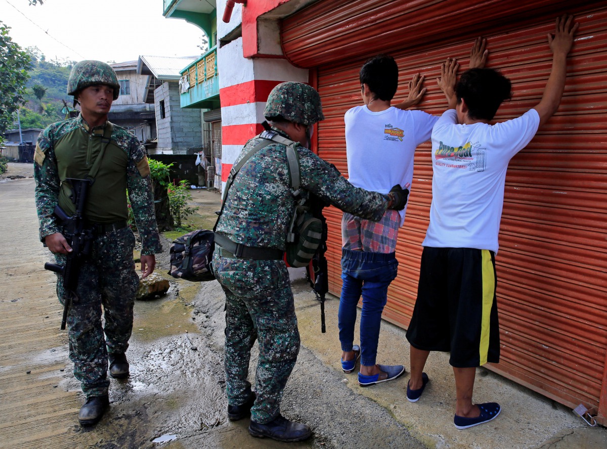 A government soldier frisks a resident who evacuated his home in Sarimanok village, Marawi City, Philippines June 1, 2017, during an ongoing assault of government troops on insurgents from the Maute group, who have taken over large parts of the city. Reut