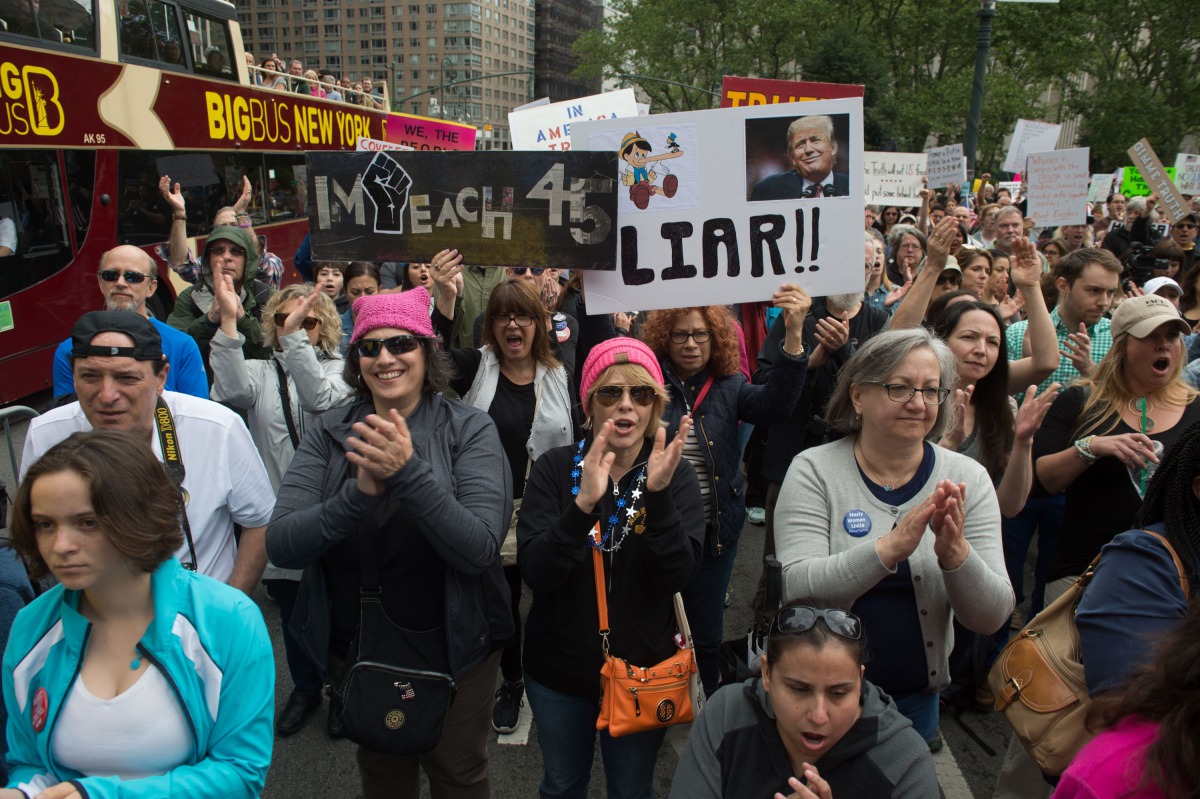 People hold signs at the March for Truth on June 3, 2017 in New York. The marchers are calling for a fair and impartial investigation into alleged Russian influence in 2016 US elections and for US President Donald Trump to release his tax returns. (AFP / 