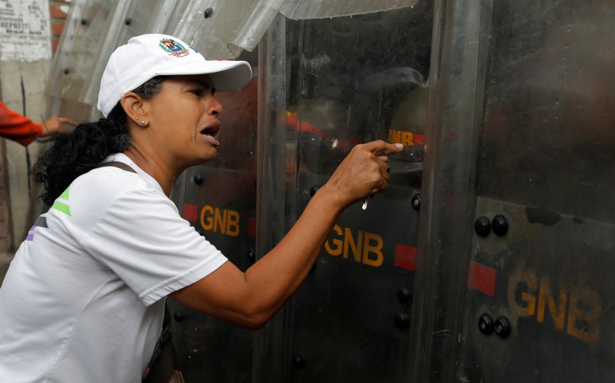 Demonstrator reacts against riot security forces during the 'march of the empty pots' against Venezuelan President Nicolas Maduro's government in Caracas, Venezuela, June 3, 2017. (REUTERS/Marco Bello)