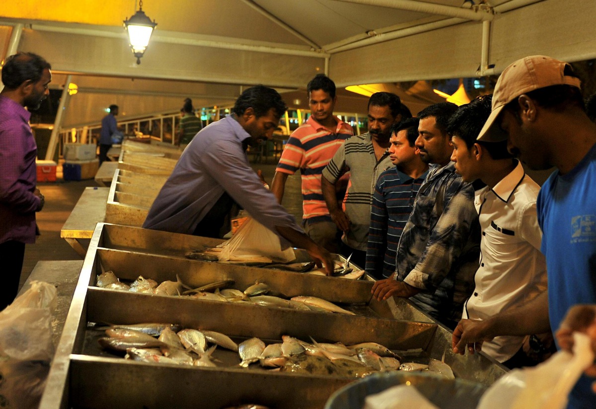 (File photo of people buying fish from the Doha Corniche. Photo by Baher Amin)