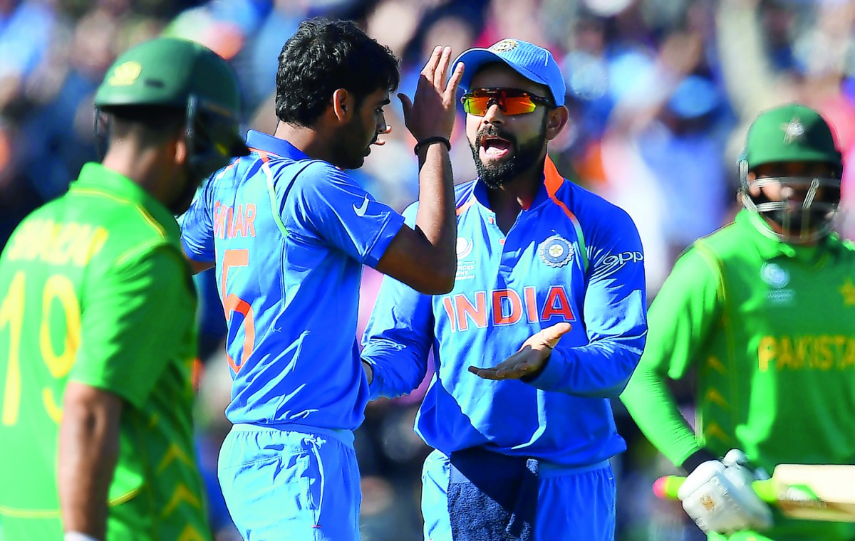 India's Bhuvneshwar Kumar (second left) celebrates the wicket of Pakistan's Ahmed Shehzad with India's captain Virat Kohli during the ICC Champions trophy match at Edgbaston in Birmingham, yesterday.