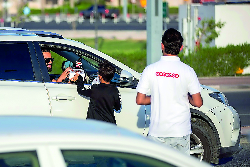 Ooredoo volunteers gift water and dates to a motorist at Aspire Zone.