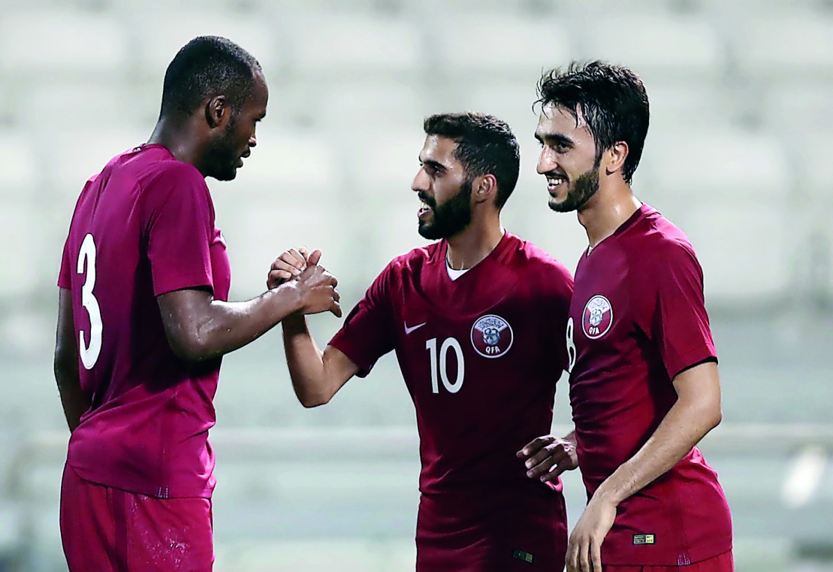 Abdul Kareem Hassan (left) of Qatar celebrates with team-mates after scoring a goal.