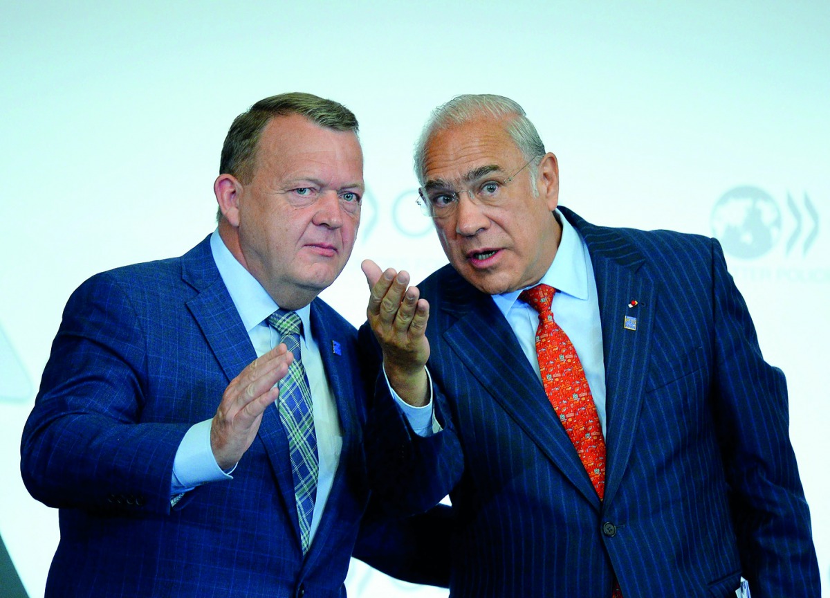 Prime Minister of Denmark Lars Rasmussen (left) speaks with OECD General-Secretary Angel Gurria after addressing the opening of a meeting at OECD headquarters in Paris, yesterday.