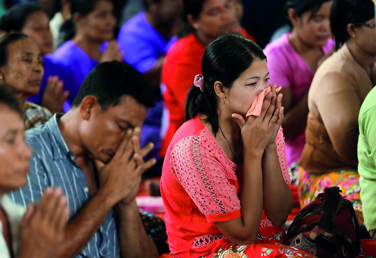 Family members of victims from a military plane crash cry during a funeral ceremony in Dawei, Myanmar, yesterday. 
